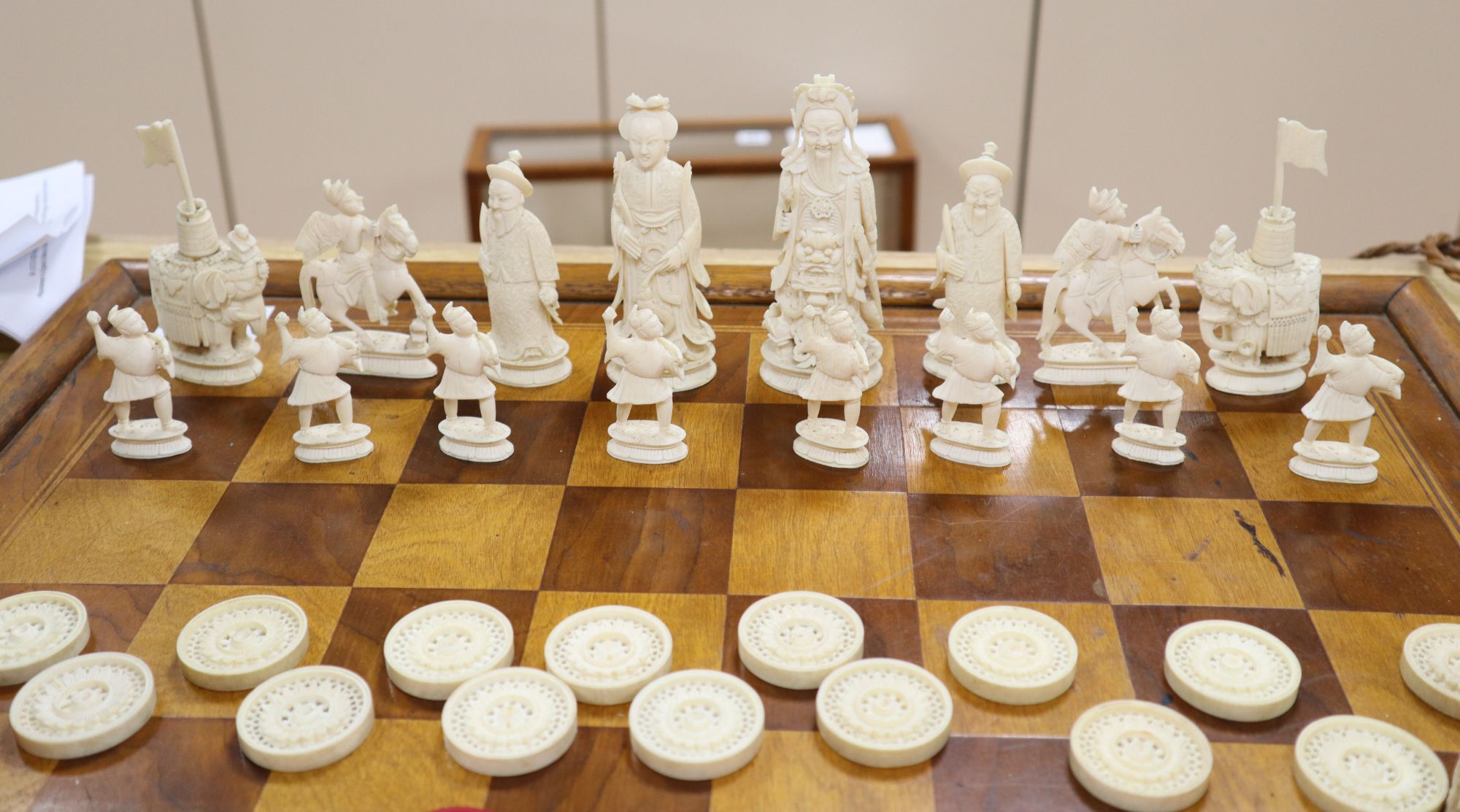 A 19th century Cantonese ivory chess and draught set, with later wood chess board and display cabinet